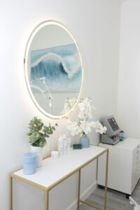 Beauty treatment room design with treatment bed, mirror and soft styling